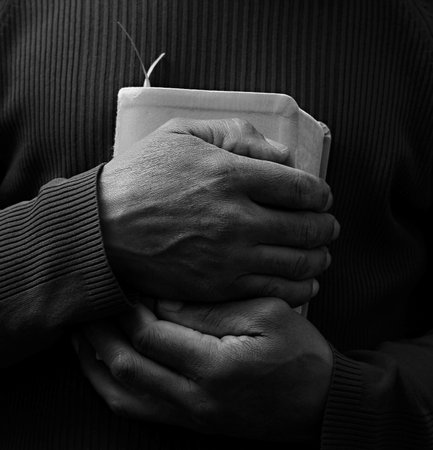 man praying with bible with grey black background with people stock image stock photoの写真素材