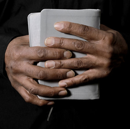 man praying with bible with grey black background with people stock image stock photoの写真素材
