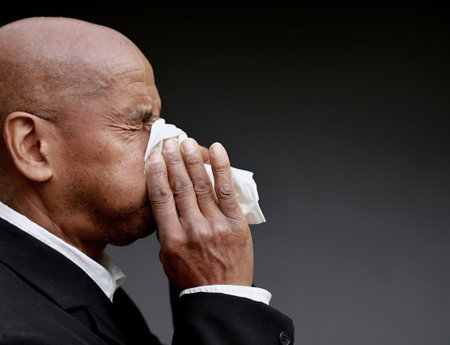 blowing nose after catching the cold and flu with grey background with people stock image stock photoの写真素材