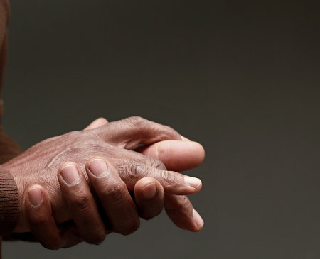 Close up of hands of a senior African American man on grey background
