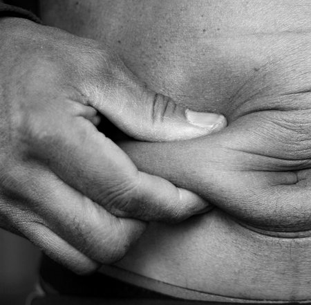 Closeup of a man suffering from pain in the stomach. Black and white.