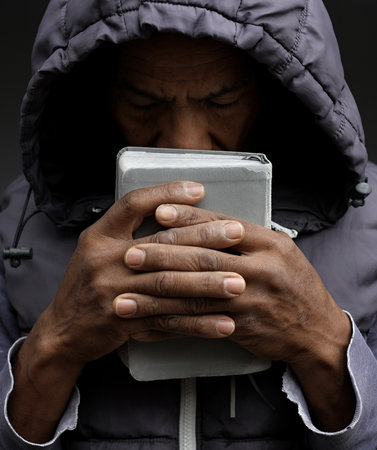 Close-up portrait of a young black man wearing a hooded jacket