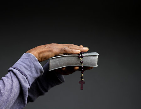 Closeup of a man hands holding a holy bible with a rosary