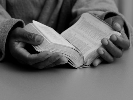 Hands of a man reading a book. Selective focus.