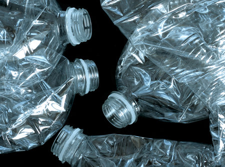crumpled plastic bottles on black background, closeup of photo
