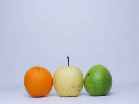 Orange, apple and lime on a white background with copy spaceの写真素材