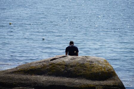 Man sitting on a rockの写真素材