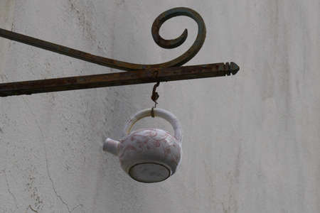Teapot suspended from a wrought iron.の写真素材