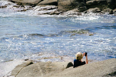 Character taking pictures by the sea.の写真素材