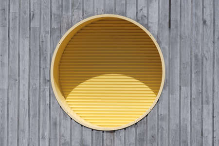 Modern architecture, round window and yellow shutter.の写真素材