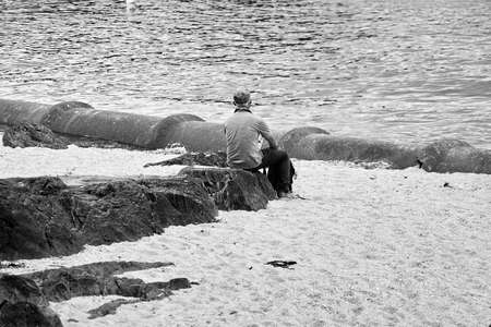 Lonely man seated seen from behind.の写真素材