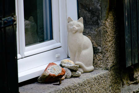 Earthenware cat on a window sill.の写真素材