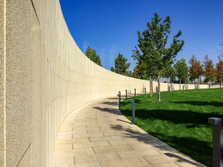 park footpath lined with stone tiles. Lawn and other vegetationの写真素材