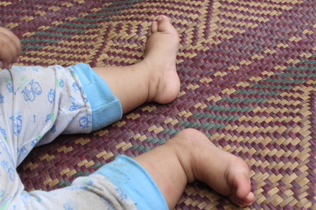 Cute pair of child's foot on the carpetの写真素材