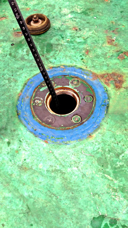 checking using a tape measure to determine the remaining oilの写真素材