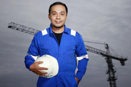 Portrait of an asian man engineer contractor with crane backgroundの写真素材