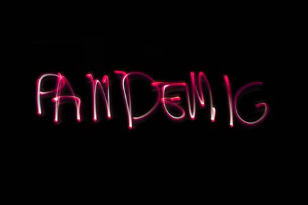 pandemic name hand drawn with a flashlight on black background