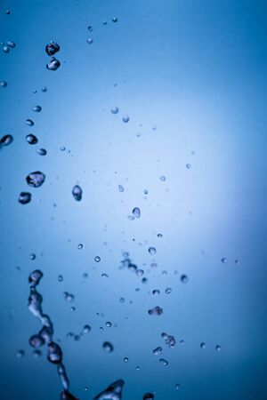 Blue background and texture with falling water droplets,の写真素材