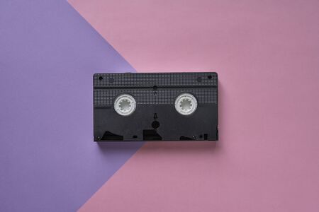 Top view of black VHS cassette on a pink and purple background.Minimalistic retro conceptの写真素材