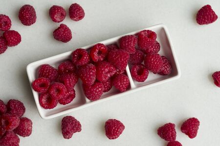 Bowl with sweet ripe raspberries on white background. Copy spaceの写真素材