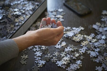 Keeping the puzzle pieces in their box and the cell phone on the table, stay at homeの写真素材