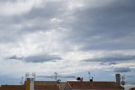 cloudy day view traditional house roof with chimney, stay at homeの写真素材