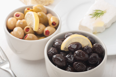 Close up of green and black olives on breakfast tableの写真素材