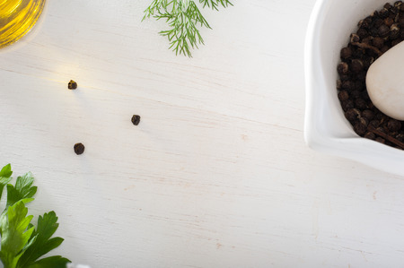 Kitchen table framed by olive oil bottle, black pepper and parsleyの写真素材