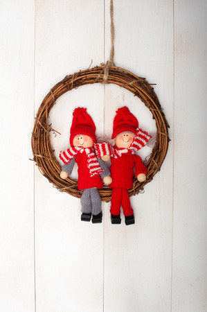 Christmas wreath on door with two kidsの写真素材