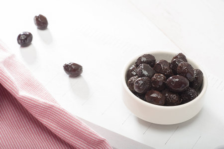 Close up of black olives on white wooden boardの写真素材