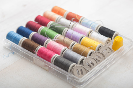 Close up of a sewing kit on white wooden background