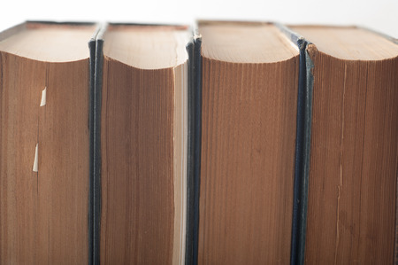 Close up of a group of old books piled together