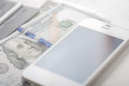 Close up of dollars, credit cards and a smart phone with shallow depth of fieldの写真素材