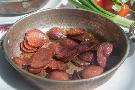 Close up of a pan of fried turkish sucuk - sausageの写真素材