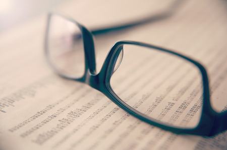 Eye glasses on newspaper showing stock exchange numbersの写真素材