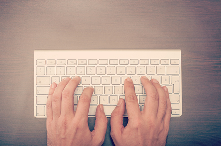 Man typing at the keyboard viewed from above