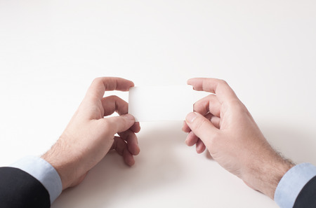 Businessman holding and looking at a business cardの写真素材