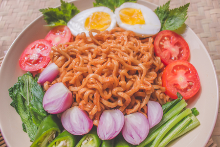 Delicious Fried Noodles on Unique Bamboo Woven Tableの写真素材