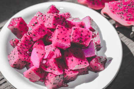 Slices of Red Dragon Fruit on Plate with Bokeh or Blur Effect Backgroundの写真素材