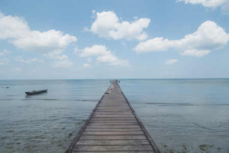 Wooden Dock, Clear Sea Water, Cloudy Sky and Tropical Beachの写真素材