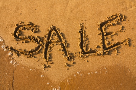 Word Sale on clean sand with water of sea. Sale summer background.の写真素材