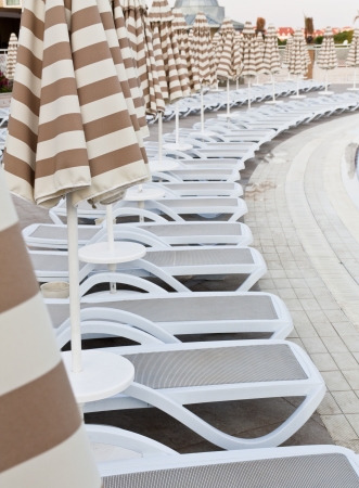 Swimming pool area of hotel with umbrella and beach chair  の写真素材