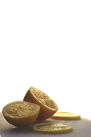 Close up of a sliced lemon on a cutting board against a white backgroundの写真素材