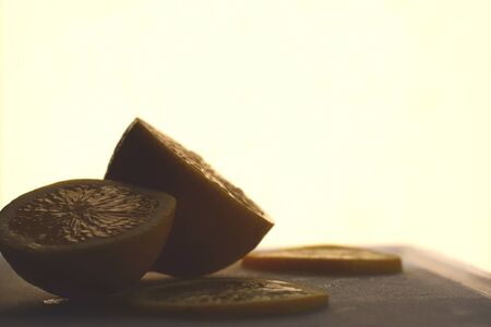 Close up of a sliced lemon on a cutting board against a bright backgroundの写真素材