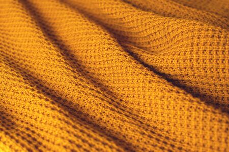 Mustard colored woollen textile. Texture detail close up.