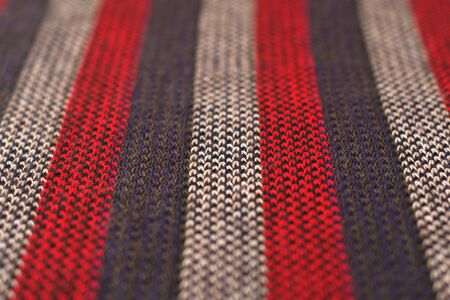 Red, gray and white striped wool cloth. Texture detail close up. Vertical convergent stripes...