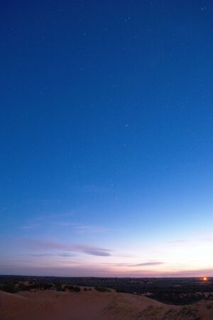 Nightfall on the desert. The first stars can be seen in the deep blue sky.の写真素材