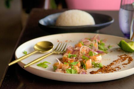 Diced raw salmon with red onions, lemon and mint, with steamed rice on the side. Close up shot.の写真素材