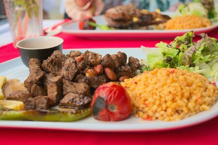 Typical turkish cuisine. Lamb kebab with almonds, tomato and whole wheat cous cous. Close up.の写真素材