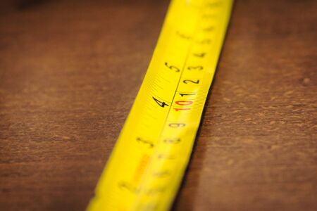Yellow metallic measuring tape. Macro close up.